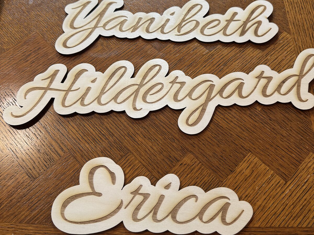 Script names engraved and cut out of basswood